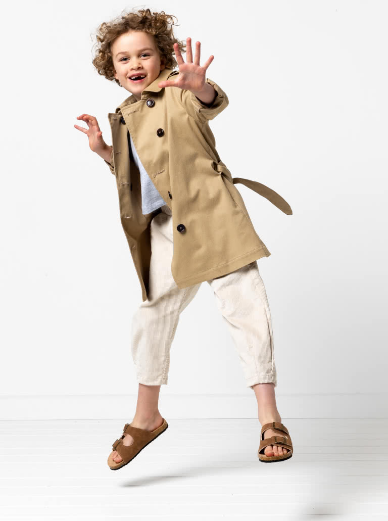 Camille Kids Trench By Style Arc - Option 1. Double breasted Trench coat with gathered skirt, belt and hood for kids 2-14. Option 2. Double breasted Trench coat straight through body, belt and hood for kids 2-14