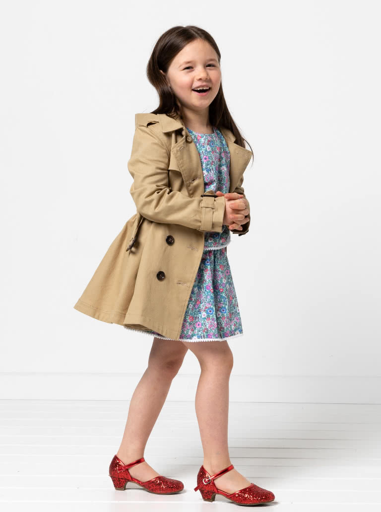 Camille Kids Trench By Style Arc - Option 1. Double breasted Trench coat with gathered skirt, belt and hood for kids 2-14. Option 2. Double breasted Trench coat straight through body, belt and hood for kids 2-14