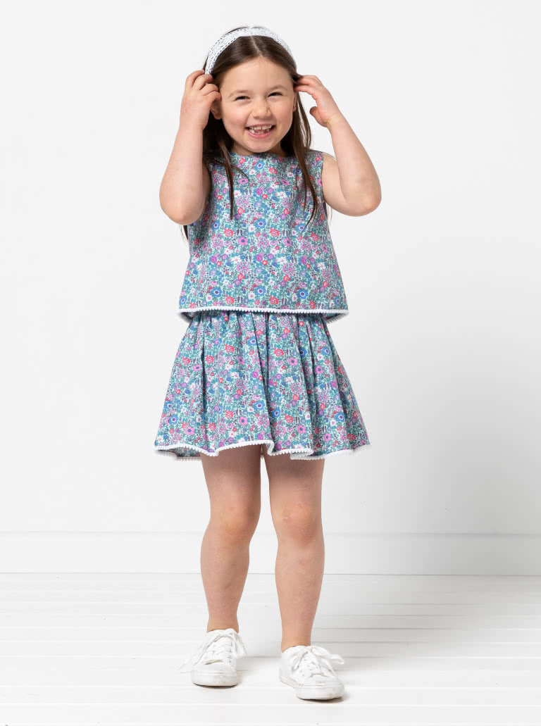 Victoria Kids Woven Dress By Style Arc - Easy-fit dress featuring a bodice overlay, elastic waist, and a gathered skirt, elegantly finished with a back neck button, for Kids 02-14